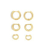 Set of three 18K yellow gold mini hoops in small, medium, and large sizes for elegant everyday wear.