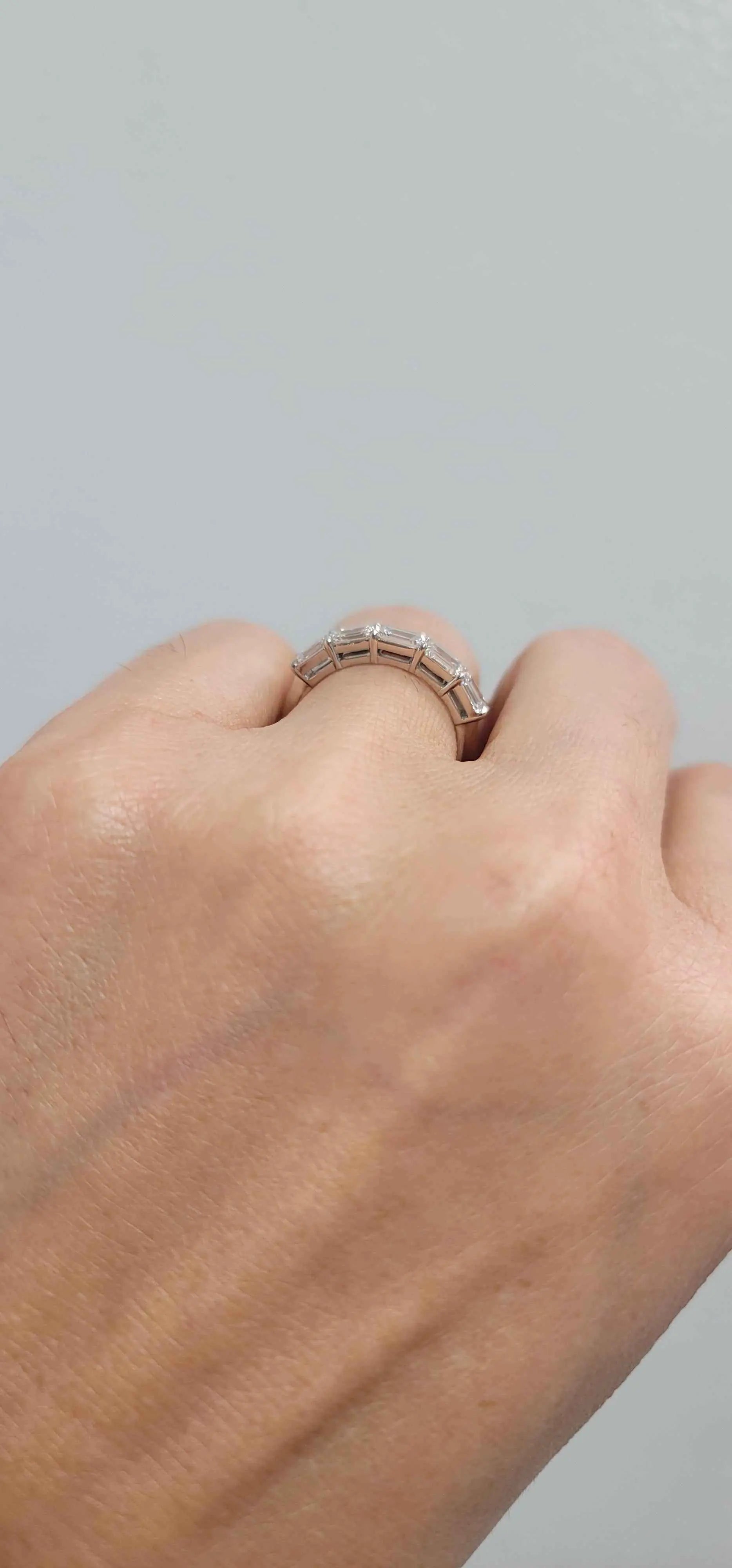 Delilah 5 Stone Anniversary Band platinum ring with five emerald cut diamonds on hand