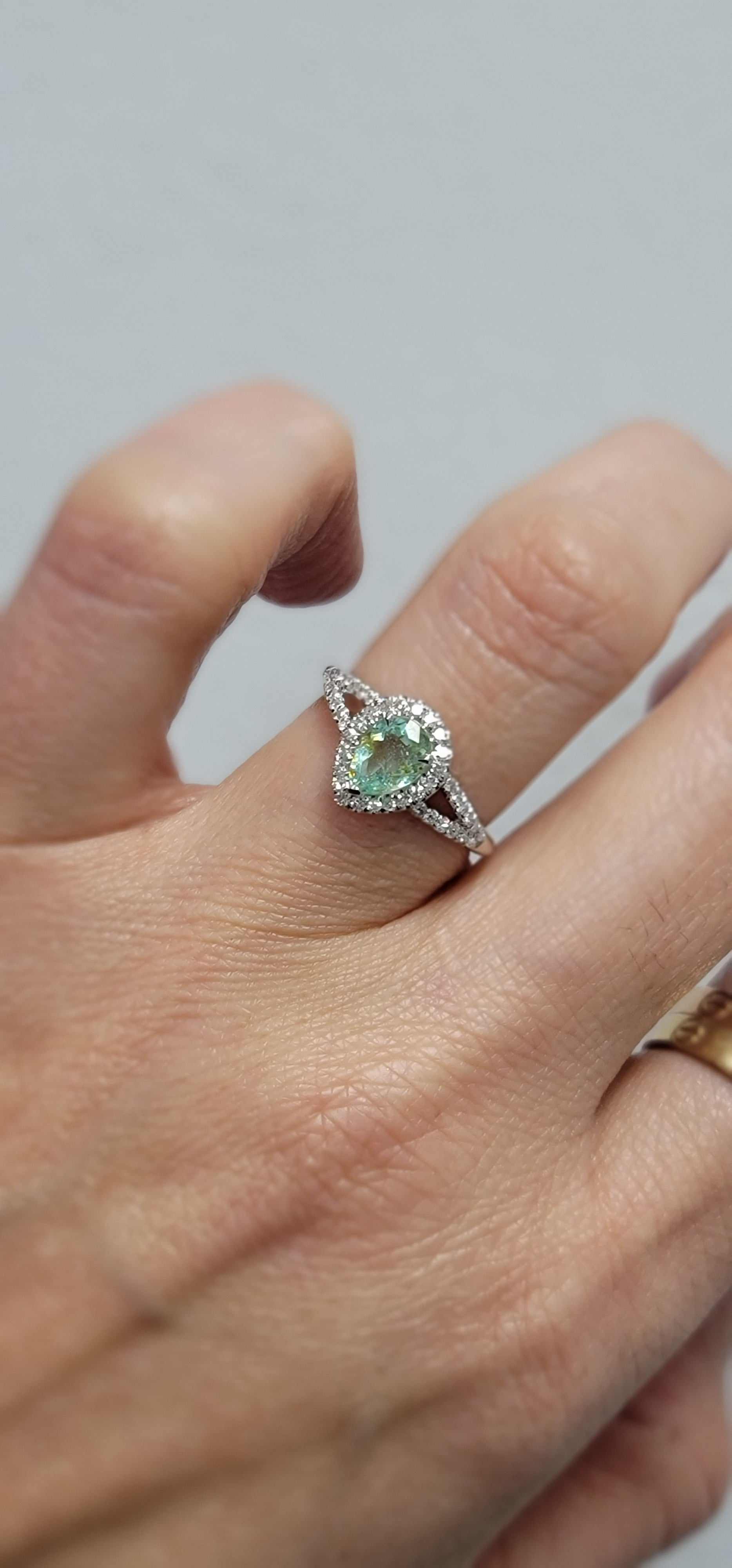 Gigi Alternative Engagement Ring with teal Paraiba Tourmaline center stone on hand