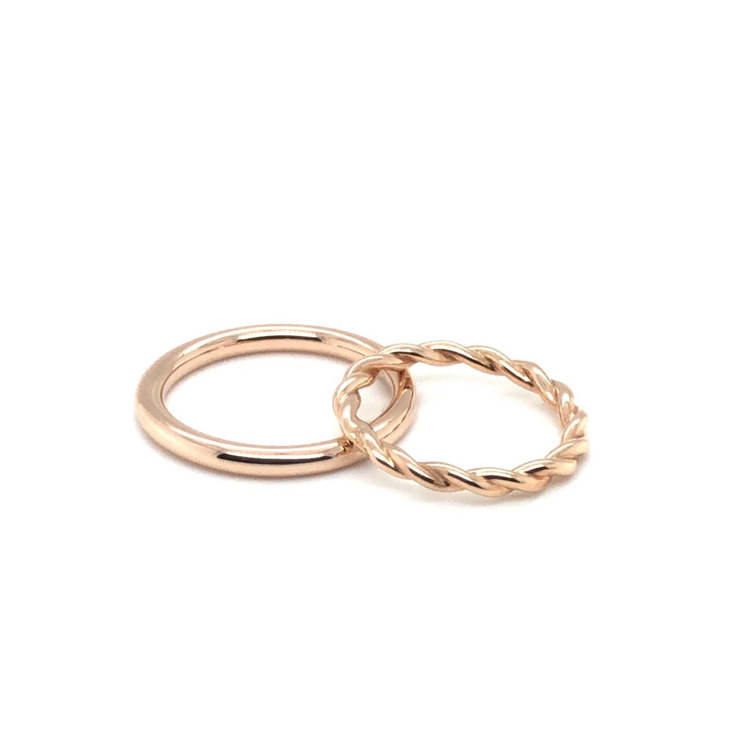 Two rose gold rings including a smooth polished band and a twisted Maxi Wedding Band.