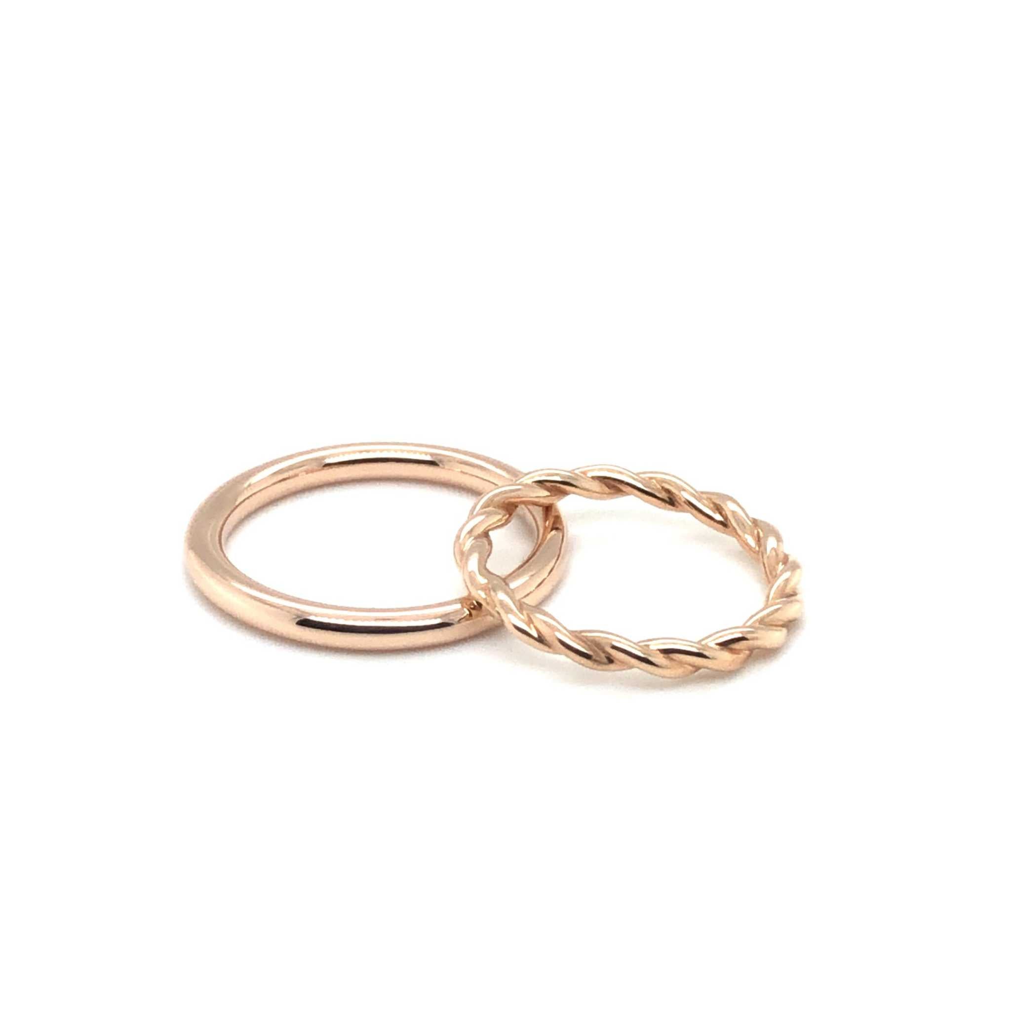 Two rose gold rings including a smooth polished band and a twisted Maxi Wedding Band.