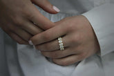 Close-up of hand wearing Olivia Seven Stone Anniversary Band with oval cut diamonds in 18k yellow gold, showcasing elegant stone anniversary band design