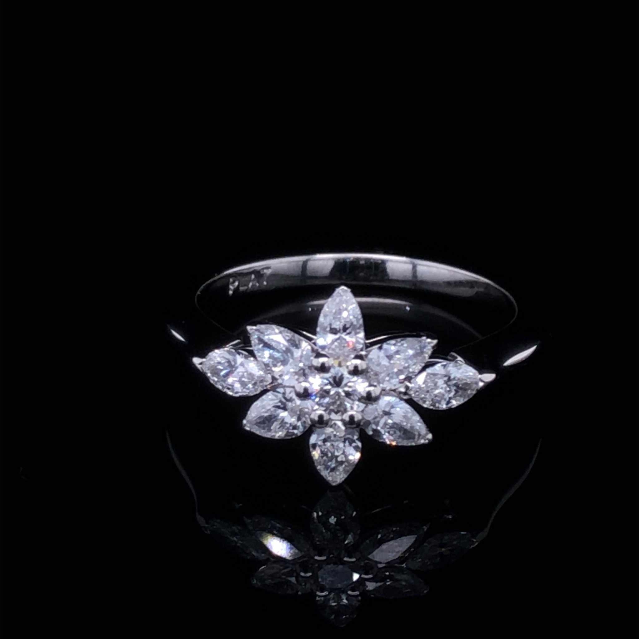 Daisy Engagement Ring with pear, marquise, and round diamonds in platinum setting reflecting light elegantly