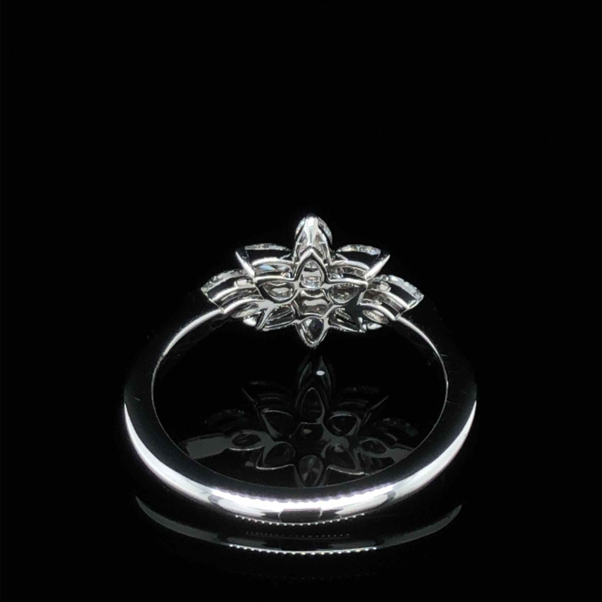 Platinum Daisy Engagement Ring with pear, marquise, and round diamonds in a knife-edge setting on black background