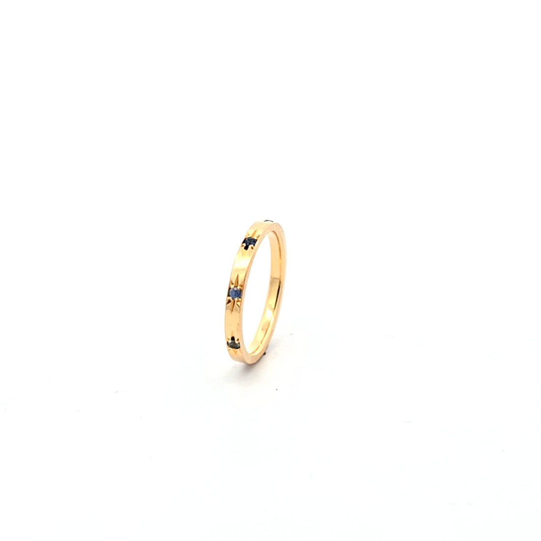 Solace band 18K yellow gold ring with blue sapphire starburst design